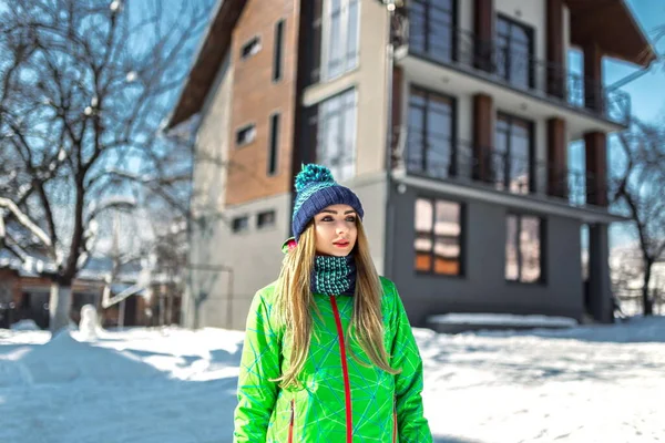 冬のスポーツ グリーンの服を着た少女が雪の天気の中外に立って ストック写真