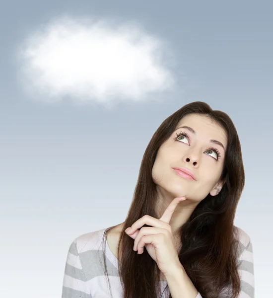 Mujer pensante mirando hacia arriba con la nube blanca por encima en backgro azul Imagen De Stock