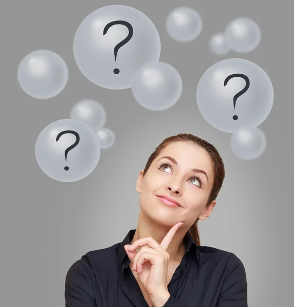 Thinking business woman looking up on many bubbles with question — Stock Photo, Image