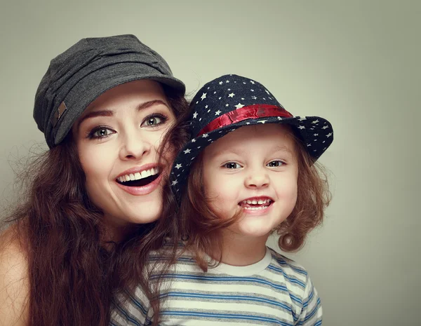 Madre y niño de moda con feliz sonrisa mirando con gorras. Vintage Imagen De Stock