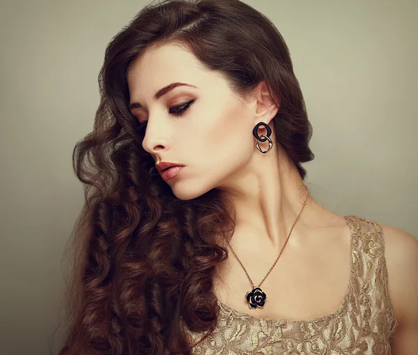 Beautiful profile of female model looking down with long brown curly hair. Vintage portrait Stock Picture