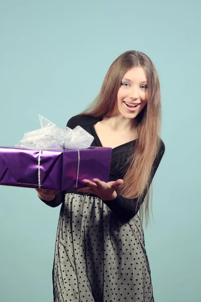 Uma bela menina feliz com um presente . — Fotografia de Stock