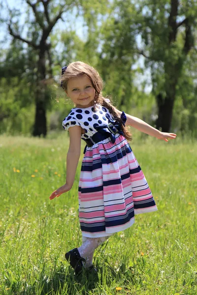 Liten flicka på gräs. — Stockfoto