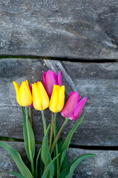 Tulips on wooden table — Stock Photo, Image