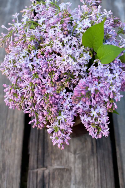 Lilacs on wooden garden table — Stock Photo, Image