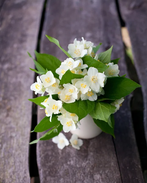 Bunch of jasmine flowers on wooden garden table — Stock Photo, Image