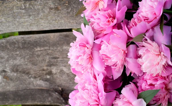 Mazzo di peonie su superficie di legno — Foto Stock