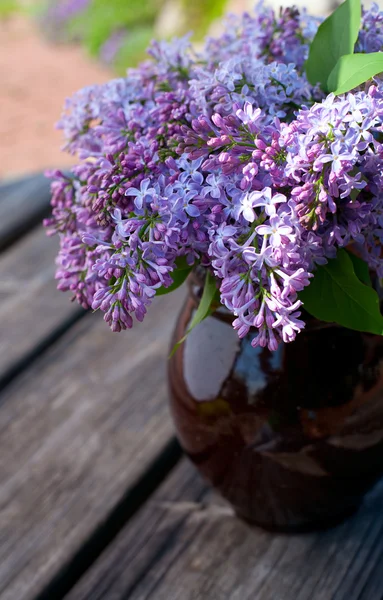Lilacs on wooden garden table — Stock Photo, Image