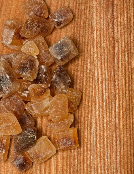 Brown caramelized sugar on wooden background — Stock Photo, Image