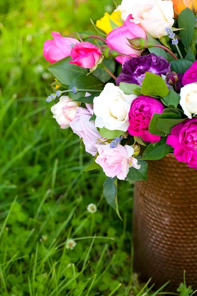 Diferentes rosas en regadera de pie sobre hierba —  Fotos de Stock