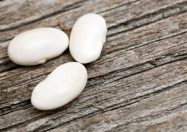 Fagioli bianchi su superficie di legno — Foto Stock