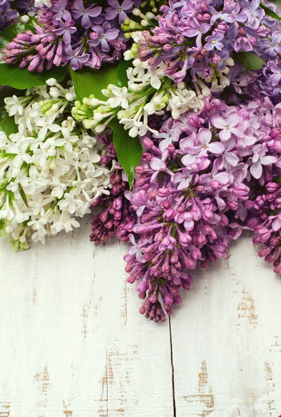 Lilac flowers on wooden table — Stock Photo, Image