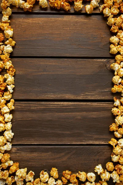 茶色の木製の表面にカラメルポップコーン — ストック写真