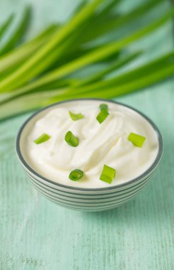 Ahşap yüzeyde dilimlenmiş soğanlı ekşi krema