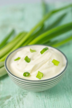 Ahşap yüzeyde dilimlenmiş soğanlı ekşi krema