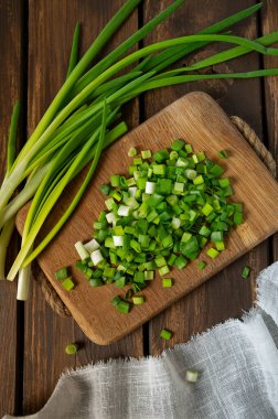 Salata veya ahşap yüzeyde baharat için dilimlenmiş taze soğan.