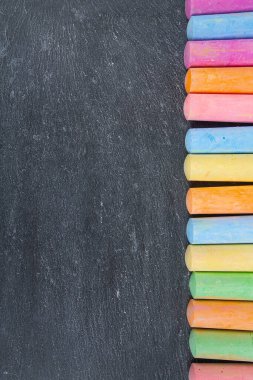 Siyah tebeşir yüzeyinde renkli tebeşirler