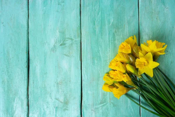 Turkuaz yüzeyde narsisli çiçekler