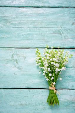 beautiful flowers of lily of the valley on turquoise surface