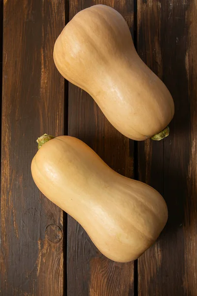 Fresh butternut squash on wooden background. Healthy food concept. Top view.