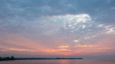 Bulutların, nehrin ve zamanın ardında yükselen güneş.