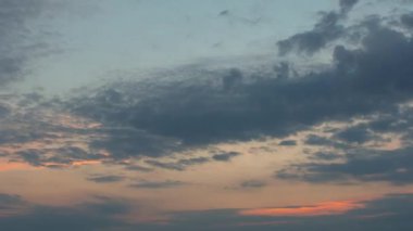 Turuncu gökyüzünde hızlı hareket eden bulutlarla gün doğumu, din, zaman kaybı