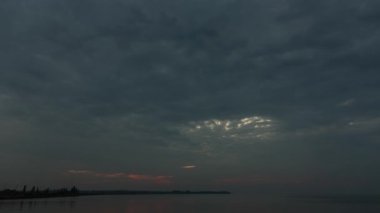 Turuncu gökyüzünde hızlı bulutlarla gün doğumu, din, nehir, zaman kavramı