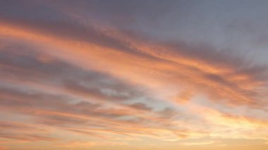 Yazın kırmızı gün batımı, bulutlar dalgalar gibi süzülür, zaman akıp gider.
