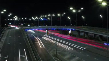 Büyük bir gece şehrinin yolundaki arabaların ışıkları, zaman aşımı, raylar.