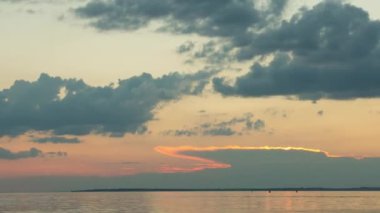Çok güzel turuncu gün batımı bulutlarla birlikte nehrin üzerinde, zaman akıp gidiyor.