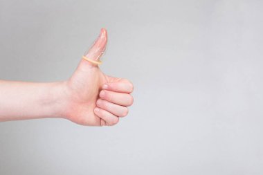 Erkeklerin elinde güvenli seks prezervatifi, doğum kontrol hapı.