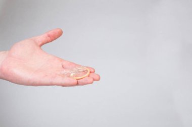 Erkeklerin elinde güvenli seks prezervatifi, doğum kontrol hapı.