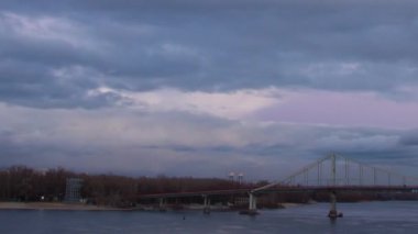 Kiev 'de gün batımında nehirden geçen büyük köprü, akşam, kış