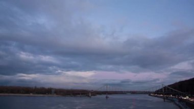 Kiev 'de gün batımında nehir boyunca büyük bir köprü, hızlı bulutlar.