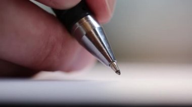Beyaz bir kağıt üzerinde tükenmez kalemle imza atan bir adam. Önemli kayıtlar. Ofis işleri. Makro görünüm