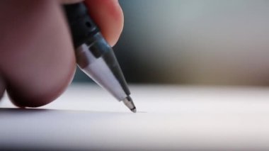 Beyaz bir kağıt üzerinde tükenmez kalemle imza atan bir adam. Önemli kayıtlar. Ofis işi