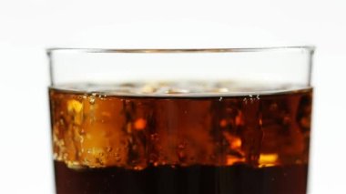 Beyaz arka planda bir sürü kabarcık olan bir bardakta soda.