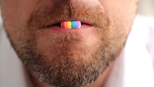 Sakallı Bir Adam Dudaklarında Lgbt Gökkuşağı Renginde Bir Hap Tutuyor — Stok video