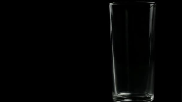 在黑色背景上倒空果汁的杯子 — 图库视频影像