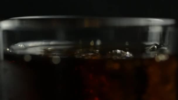 Ένα Ποτήρι Σόδα Ουίσκι Και Πάγο Που Στριφογυρίζει Μαύρο Φόντο — Αρχείο Βίντεο