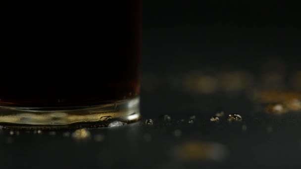 左への動きと黒の背景にガラスの近くにこぼれたソーダ — ストック動画