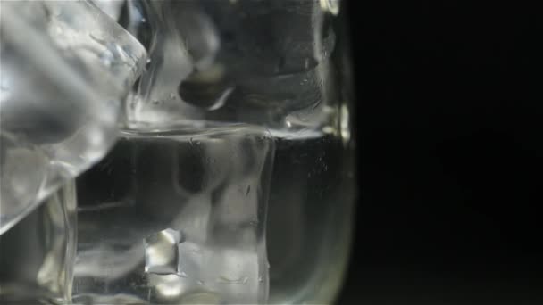 威士忌倒入酒吧附近一个黑色背景的冰杯中 — 图库视频影像