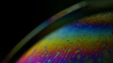 Siyah arka planda renkli kan nakli yapılan güzel bir sabun köpüğü.