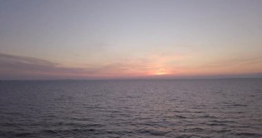 Nehir kıyısında gün batımında yükselen küçük dalgalarla