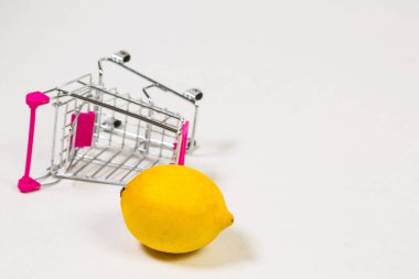 Beyaz bir arka planda market arabasında limon