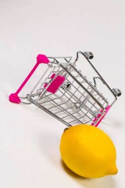 Beyaz bir arka planda market arabasında limon