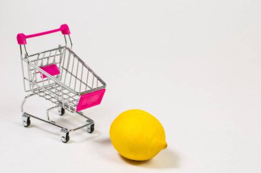 Beyaz bir arka planda market arabasında limon