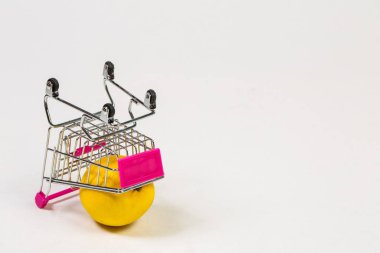 Beyaz bir arka planda market arabasında limon