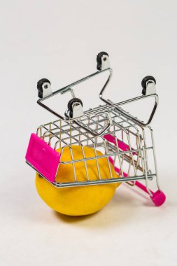 Beyaz bir arka planda market arabasında limon