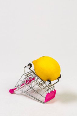 Beyaz bir arka planda market arabasında limon